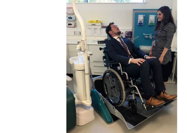 Cllr Stephen Morgan tries out the wheelchair recliner for patients with disabilities at the Somerstown Dental Clinic
