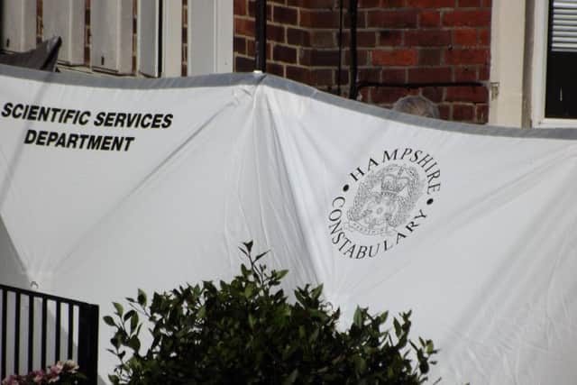 Forensics officers in Outram Road, Southsea, where a man's body was discovered and another held on suspicion of murder