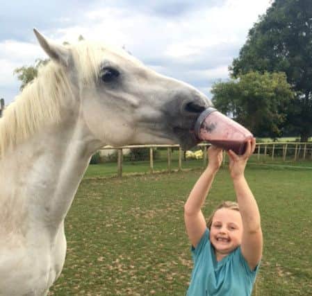 Catriona Cleugh's seven-year-old daughter sharing her smoothie with Catriona's horse Hugo