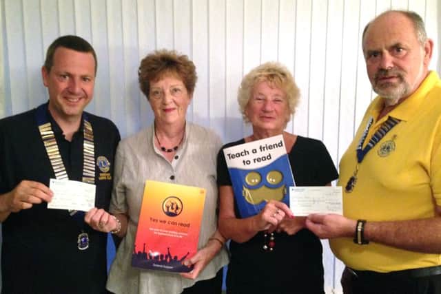 Robert Armstrong-Collett, president of Fareham Lions Club, Una Sadler and Linda Curtis from We Can Read and David Andrews, president of Gosport and Lee-on-the-Solent Lions Club handing over cheques