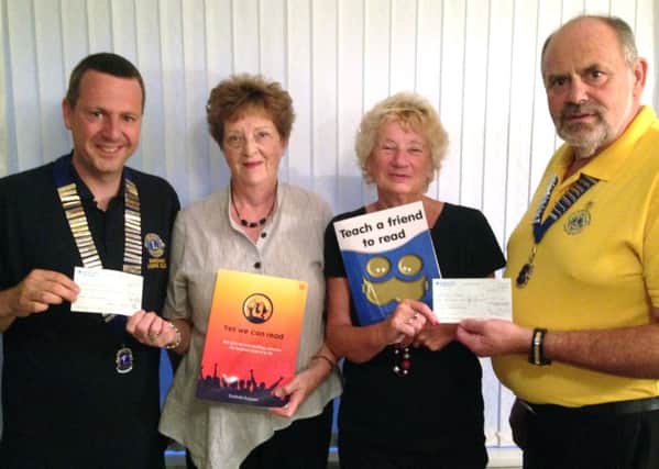 Robert Armstrong-Collett, president of Fareham Lions Club, Una Sadler and Linda Curtis from We Can Read and David Andrews, president of Gosport and Lee-on-the-Solent Lions Club handing over cheques