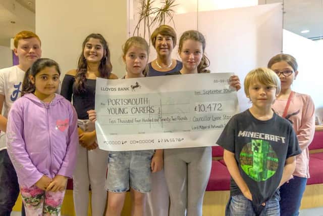 Cllr Stagg presenting the cheque to young carers Oliver, Maryam, Maaria, Hannah, Olivia, Jake, Kirstie