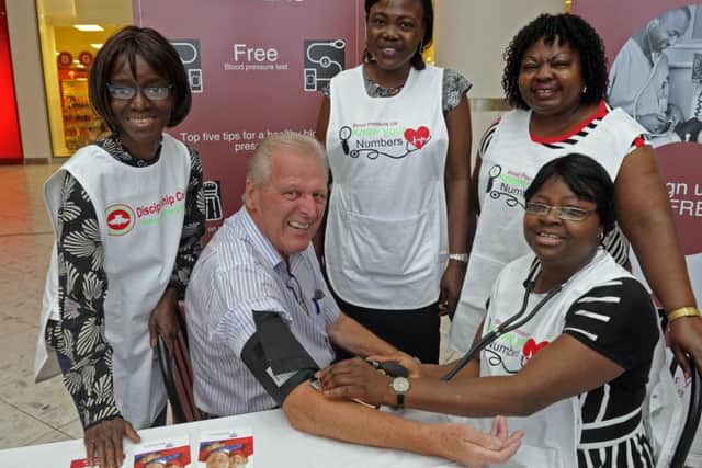 Edward Rees from Portsmouth gets his blood pressure checked by volunteers, from left, Celestine Jamiru, Oluwaseye Olaitan, Lisette Possi and sitting Tola Adeojo during a drop in session at Cascades in Portsmouth Picture Ian Hargreaves (161225-2)