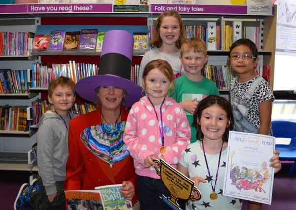 From the left are eager readers Joshua Bull, seven, volunteer Sarah Allen as Willy Wonka, Ellie Bull, four (middle), Erin Coffey, nine, Quinn Coffey, six, Olivia Barker, eight and Audrey Peralta, seven 	Picture: Loughlan Campbell