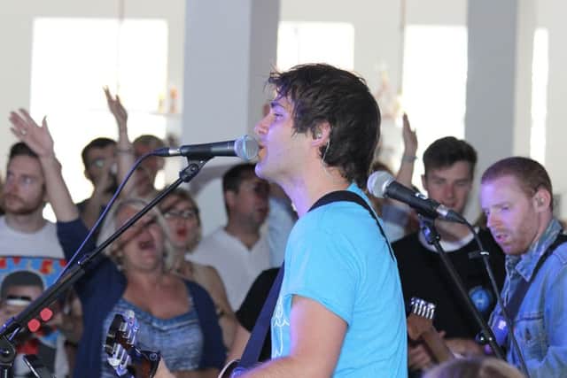 The churchs worship leader Sam Parker leading the musical praise session