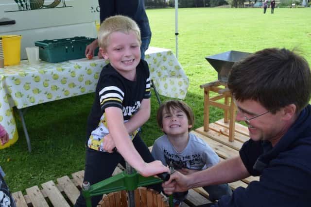 Oscar Coote, six, presses apples with Zak McCartney, six, under Hill Farm Juice's Will Dobson's watchful eye.
Picture: Loughlan Campbell