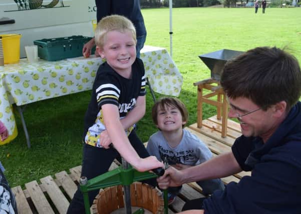 Oscar Coote, six, presses apples with Zak McCartney, six, under Hill Farm Juice's Will Dobson's watchful eye.

Picture: Loughlan Campbell