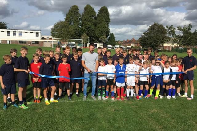 Pompey player Ben Close cuts the ribbon at the official opening of the field at Purbrook Park School