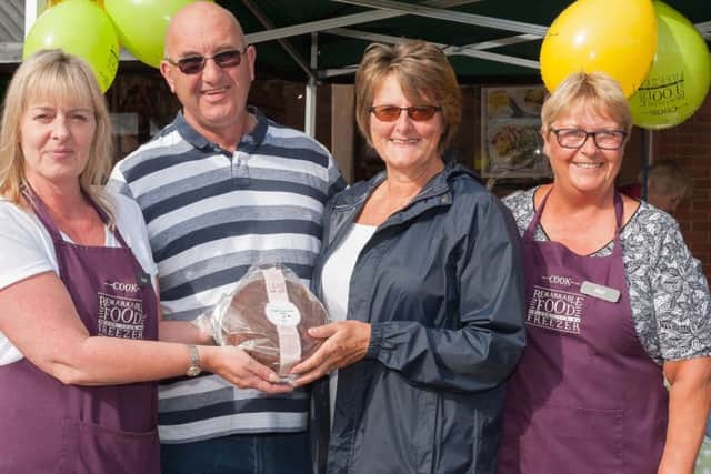 Tracy Fryer, manager of Cook shop, presents Brian and Lynn Duffin who were married just two weeks ago, with a cake
Picture: Keith Woodland (160210-162417001)