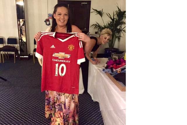 Janine Taylor with a signed Man United shirt at the bras and pants auction