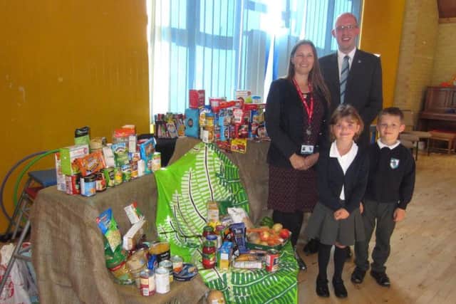 Headteacher Mandy Hall, curate David Morgan, and pupils at Fairfield Infant School in Havant with some of the donated food