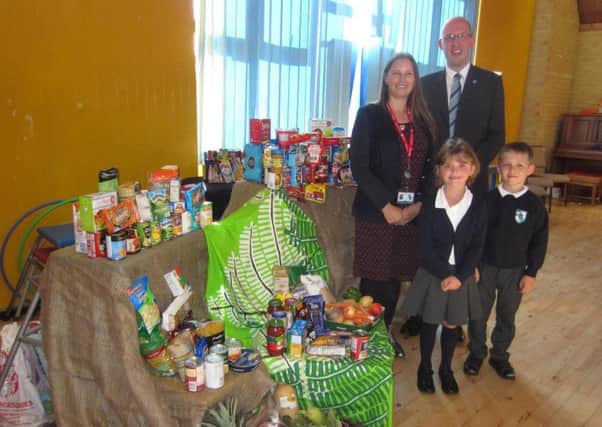 Headteacher Mandy Hall, curate David Morgan, and pupils at Fairfield Infant School in Havant with some of the donated food