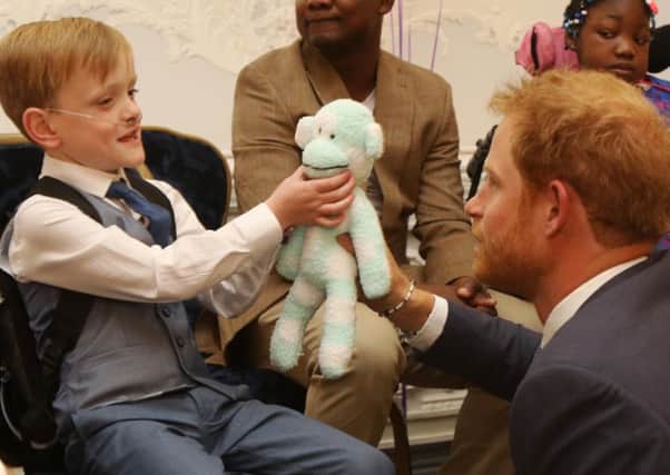Sam Merrick meets Prince Harry and presents him with Mr Monkey, a homemade teddy made from socks Picture: Antony Thompson - Thousand Word Media
