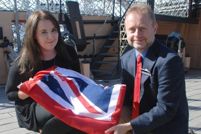 Kate Jamieson receiving the HMS Victory flag from head of heritage and development at the NMRN Nick Hewitt, next to where Nelson fell on the warship