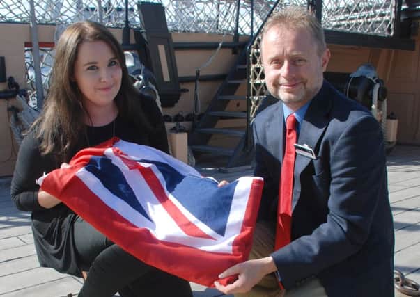 Kate Jamieson receiving the HMS Victory flag from head of heritage and development at the NMRN Nick Hewitt, next to where Nelson fell on the warship
