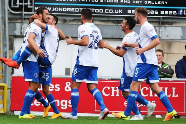 Christian Burgess is mobbed by his Pompey team-mates after scoring the winner against Leyton Orient today Picture: Joe Pepler