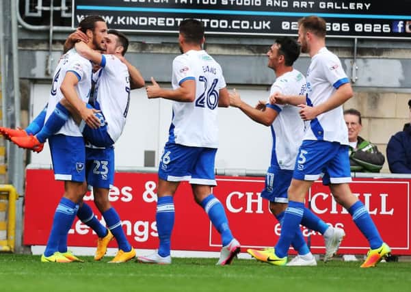 Christian Burgess is mobbed by his Pompey team-mates after scoring the winner against Leyton Orient today Picture: Joe Pepler