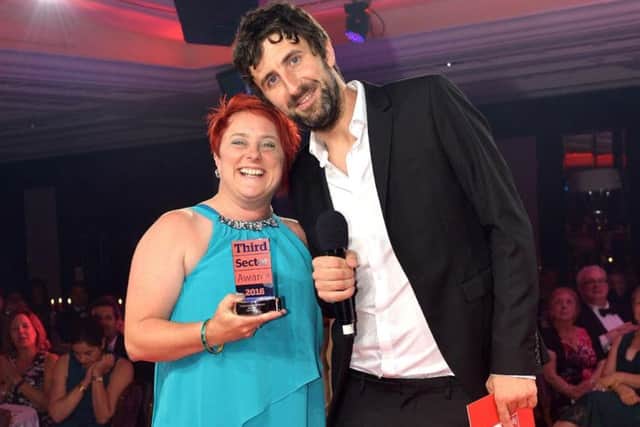 Zoe Grant receiving her award from comedian and host Mark Watson at The Lancaster Hotel in London
