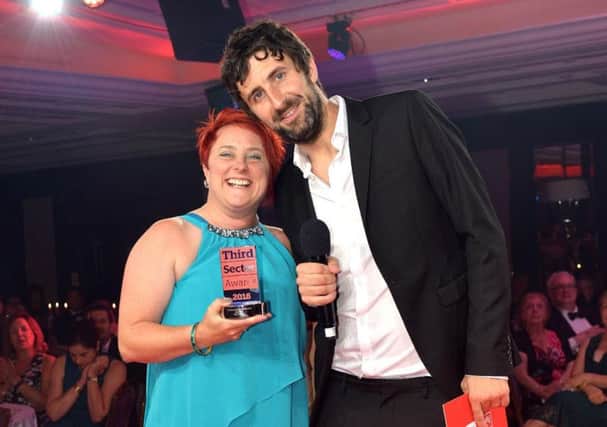 Zoe Grant receiving her award from comedian and host Mark Watson at The Lancaster Hotel in London