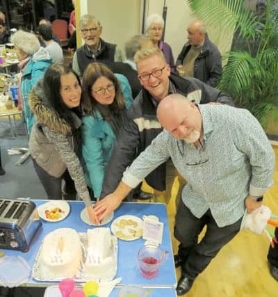 The founders of Friday Fridge (l to r) Nikki Chester, Catherine Benford and the Rev Mark Rodel cutting a cake with the current leader Jim Campbell (right)