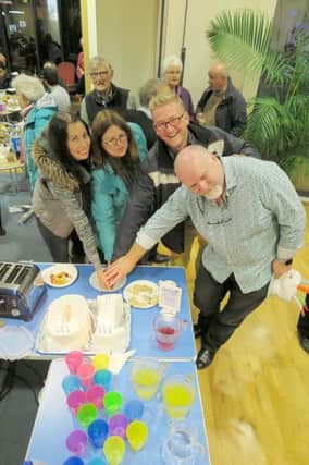 The founders of Friday Fridge (l to r) Nikki Chester, Catherine Benford and the Rev Mark Rodel cutting a cake with the current leader Jim Campbell (right)