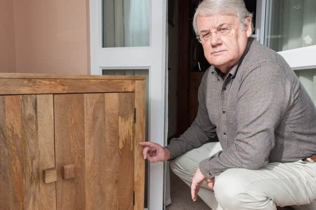 Geoffry Burton with the blemish on his oak sideboard