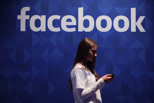 File photo dated 03/11/15 of a woman using her phone under a Facebook logo, as insurer Admiral announced that first-time drivers can receive reduced insurance quotes by allowing their Facebook profiles to be scoured in a bid to determine their personalities. PRESS ASSOCIATION Photo. Issue date: Wednesday November 2, 2016. The insurance company said that those buying their first car could join the optional scheme to receive a discount of up to 15%. See PA story TRANSPORT Facebook. Photo credit should read: Niall Carson/PA Wire TRANSPORT_Facebook_072707.JPG
