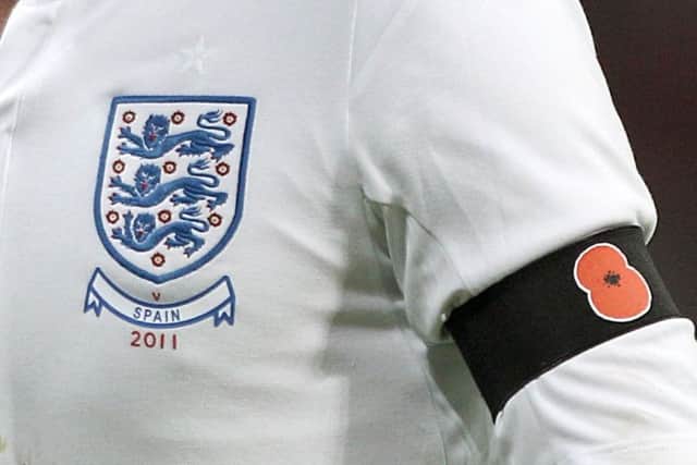 File photoof an England player wearing a black armband with a poppy symbol on aside the England badge in 2011