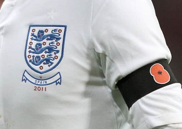 File photoof an England player wearing a black armband with a poppy symbol on aside the England badge in 2011