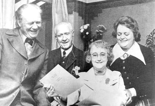 Actress Ann Noble and her husband, Lester Philcox (left), show stills from their latest picture to Ann's parents, Mr and Mrs P  Noble-Airy