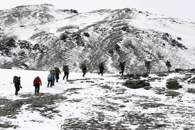 Members of HMS Protector's ship's company climb out of Fortuna Bay to complete the last part of Shackleton's walk.