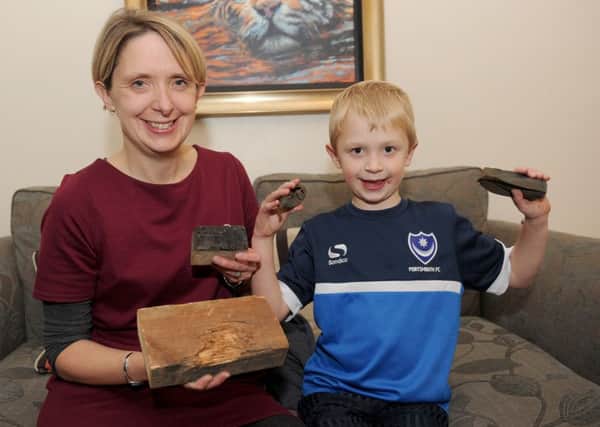 Andrea Wingfield with her son Toby Wingfield and the fire bomb that was found along with some of the damaged wood from the loft 

Picture: Sarah Standing (161564-6891)