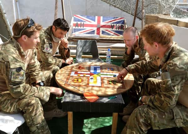 Prince Harry playing uckers while on duty in November 2012. Picture credit: John Stillwell/PA Wire