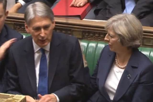 Prime Minister Theresa May congratulates Chancellor Philip Hammond after he delivered the Autumn Statement in the House of Commons