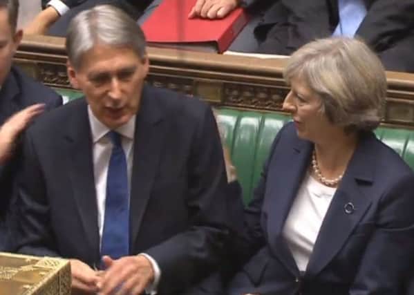 Prime Minister Theresa May congratulates Chancellor Philip Hammond after he delivered the Autumn Statement in the House of Commons