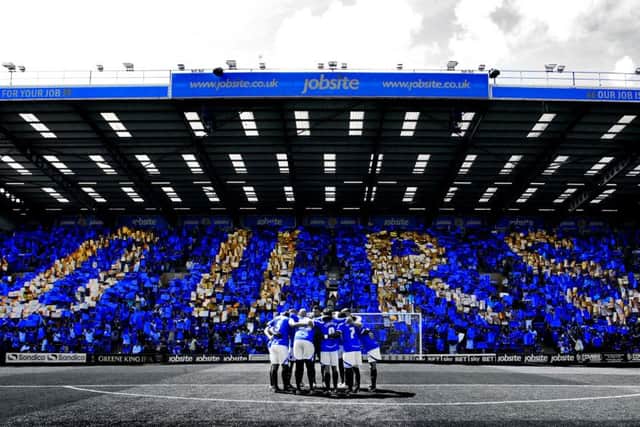League two -  Portsmouth vs Oxford United - 03/08/13-  Pompey player in a huddle before the match infont of the Fratton end holding up cards reading "OURS" to represent the Fans taking over as owners of the club PPP-160720-180403002