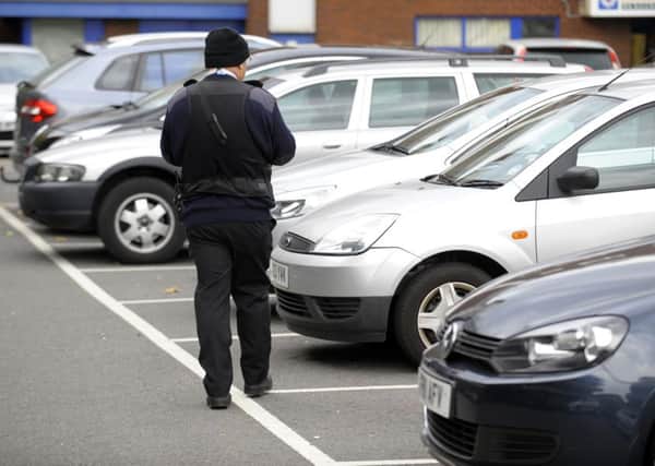 A parking warden checking tickets in Isambard Brunel car park, Portsmouth