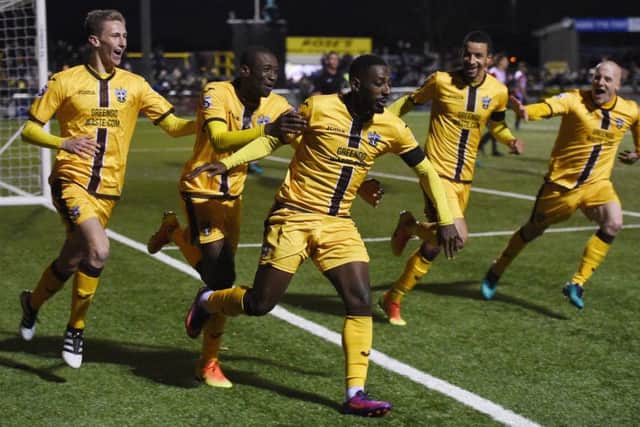 Adam May, left, rushes to celebrate with Roarie Deacon after his stoppage-time winner for Suton United against Cheltenham in the FA Cup on Saturday