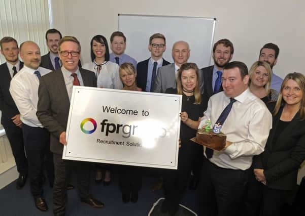 Mark Foster, left at the front, and joint owner Paul Simpson, holding the cake, and the staff at FPR Group Recruitment in Havant celebrate their 25th year in business  Picture Ian Hargreaves (161340-1)