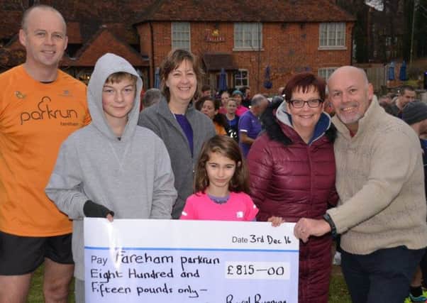 Jeff Clark, right, makes the donation to Fareham parkrun. Also pictured, from left: John Salt, Daniel Booker, Kathy O'Loughlin, Bella Emmonds and Michelle Clark