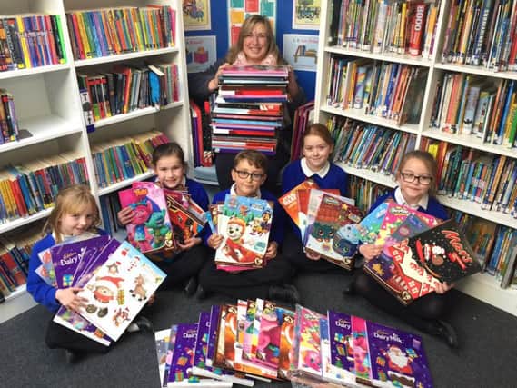 Sophie Parkinson, Evie Mulhall, Lewis Jack, Emily Slight and Brooke Gibson with Pam Hibbard from Caring Hands, handing over the Advent calendars they have collected