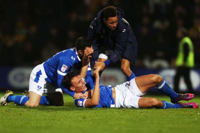 Kal Naismith is mobbed by team-mates Conor Chaplin and Kyle Bennett after his winner for Pompey Picture: Joe Pepler
