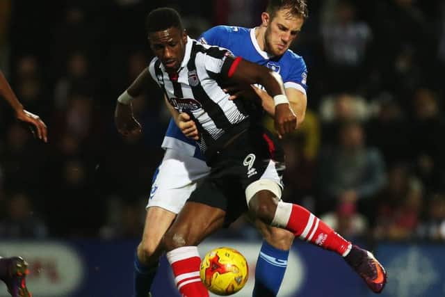 Matt Clarke keeps a close eye on Grimsby striker Omar Bogle during Saturday's game at Blundell Park Picture: Joe Pepler