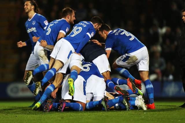 The Pompey players pile on top of Kal Naismith following his winner against Grimsby Picture: Joe Pepler