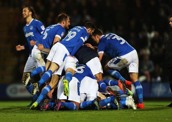 The Pompey players pile on top of Kal Naismith following his winner against Grimsby Picture: Joe Pepler
