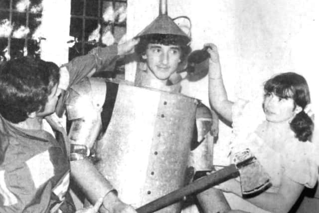 The Tin man, David Pratt, tries on the metal suit, assisted by Dorothy, Melanie Lockheart and the Scarecrow, Tony Doye