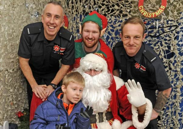 From left, firefighter Phil Jackson, Colin Webb and firefighter Mitch Creighton with Santa and Alexander Barnes from Portchester, eight Picture: Ian Hargreaves (161364-3)