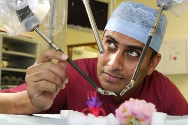QA surgeon Jim Khan with the QA robot Picture: Ian Hargreaves  (132761-8)