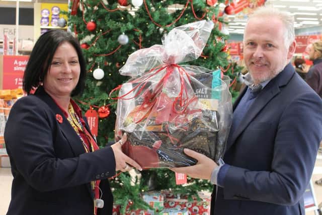 Reverend Mark James holding one of the Christmas hampers with Tesco community champion Mandi Myers
