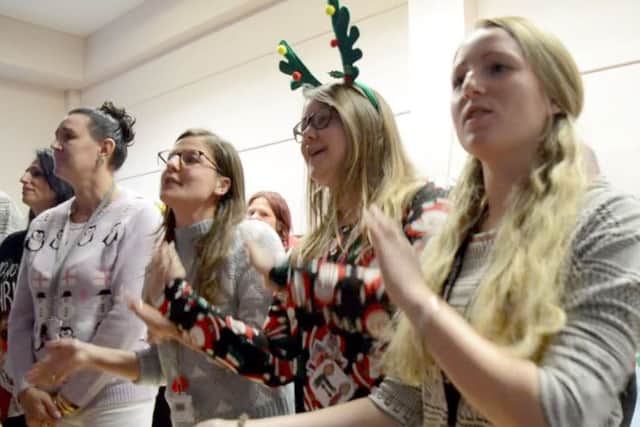 Staff at Flying Bull Academy performing Do They Know It's Christmas?